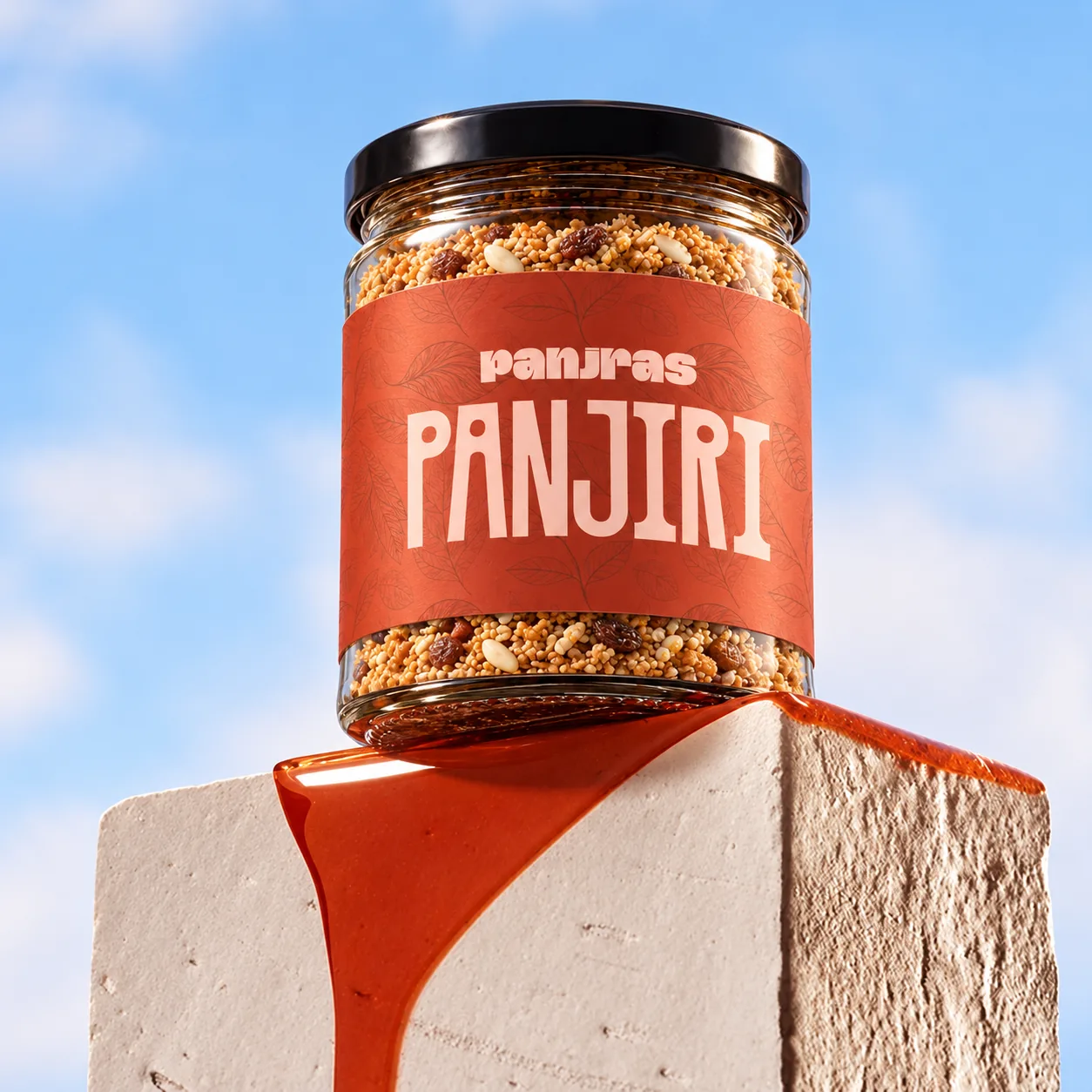 A jar of PanjRas Panjiri on a stone block against a blue sky